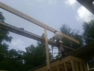 Carpenter setting a ridge beam over a new addition frame — Ice Dam Removal by Roofing Brothers in Keithsburg