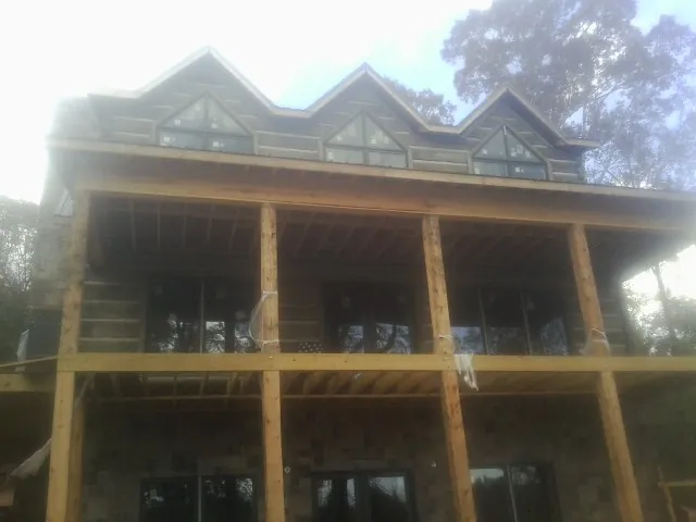 Dormers and porch framing on a large log home under construction — Roof Coating work by our crew in Keithsburg