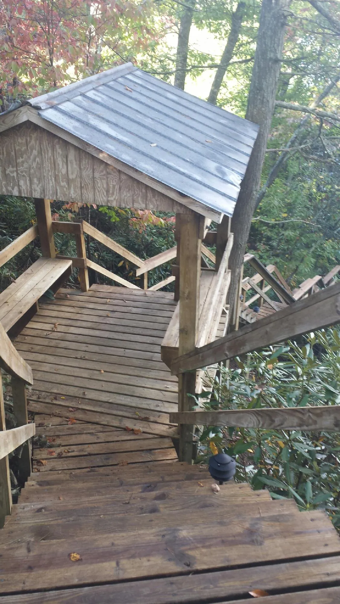 Metal roofed shelter over wooden steps on a wooded walkway — Skylight Repair & Installation work by our crew in Keithsburg