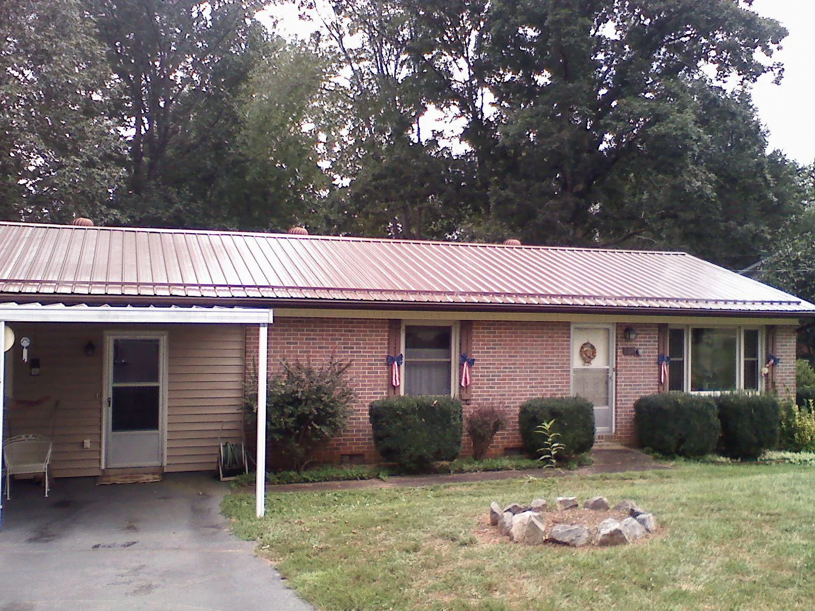 Bronze metal roof and carport on a brick ranch home — Roof Repair work by our crew in Keithsburg