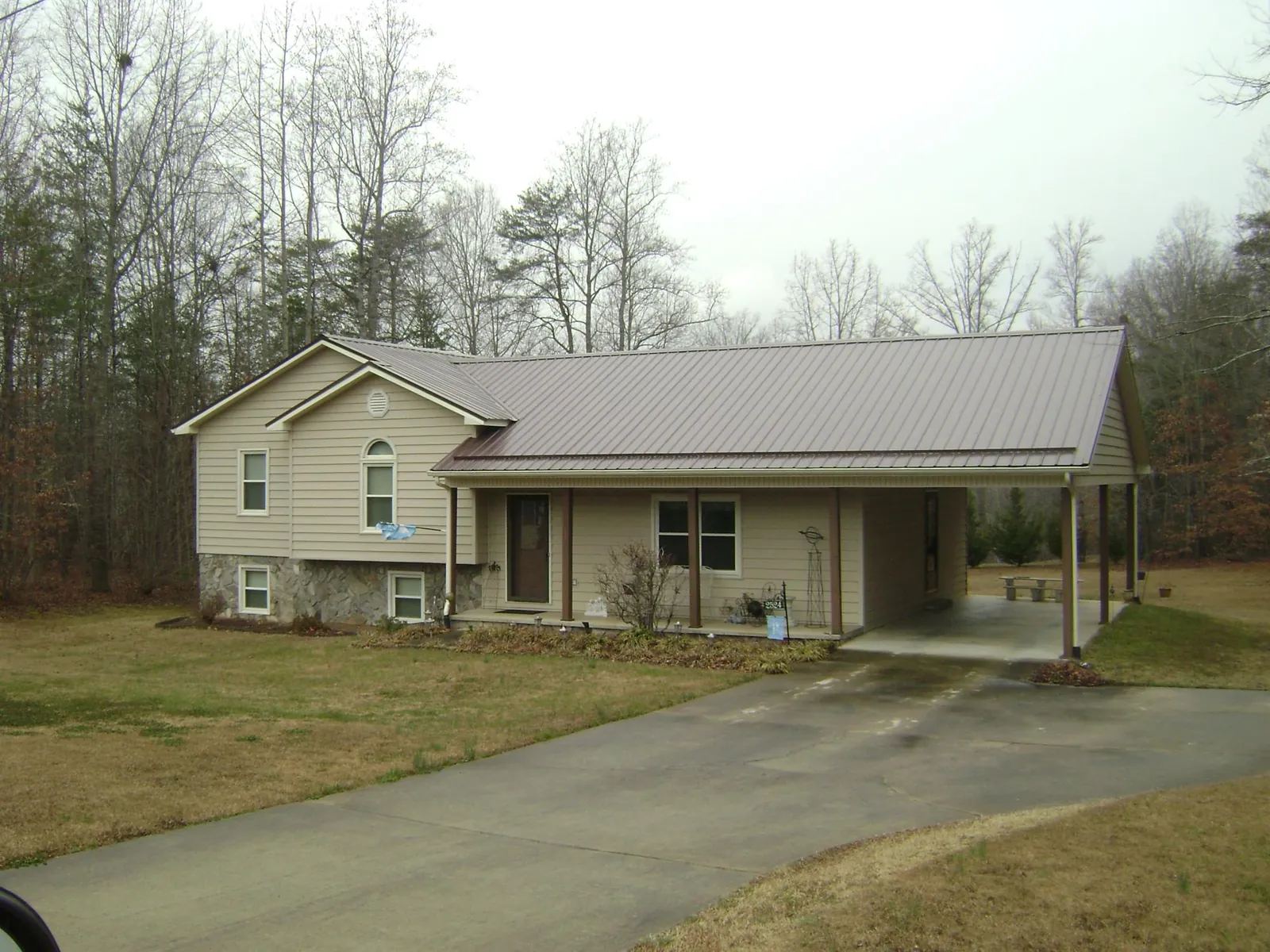 Brown metal roof on a tan split level home with an attached carport in Keithsburg